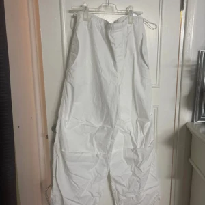 Vita cargopants från Vaillent, strl L - Säljer ett par vita cargopants från Vaillent i storlek large. Byxorna har dragsko i midjan och vid benslut, samt flera fickor på sidorna. De är tillverkade i ett lätt och bekvämt material, perfekta för en chill och avslappnad stil.