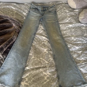 Bootcut jeans från Cheap Monday - Ljusblå bootcut jeans från Cheap Monday med låg midja och klassisk femficksdesign. Jeansen har en snygg tvättad look och är tillverkade i bomull och polyester med lite stretch för skön passform. Perfekta för dig som gillar retrovibbar och vill ha ett par jeans som sticker ut.