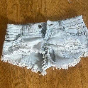 Ljusa jeansshorts från Tally Weijl - Säljer ett par ljusblå jeansshorts från Tally Weijl i storlek 34. De har slitna detaljer, fransiga kanter. Bra skick!💗