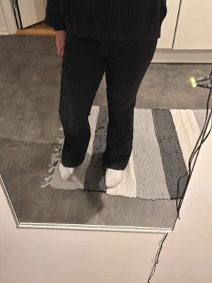 Svarta bootcut jeans Gina Tricot - Säljer ett par svarta jeans från Gina Tricot i storlek 146. Byxorna har bootcut-modell med utsvängda ben och klassisk femficksdesign. Tillverkade i jeansmaterial med snygga silverfärgade knappar och dragkedja framtill.