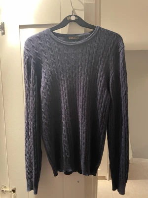 Mörkblå Stenströms Cableknit - Säljer en mörkblå kabelstickad tröja från Stenströms i 100% merinoull. Tröjan har rund halsringning och långa ärmar, perfekt för dig som gillar klassisk och stilren look. Superskön och värmande för kyligare dagar. Ganska tunn och lätt men värmer då det är merinoull. 