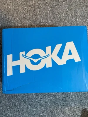 Hoka Bondi 8 sneakers svart/vit - Säljer ett par oanvända Hoka Bondi 8 sneakers i svart med vit tjock sula. Skorna har stor HOKA-logga på sidan och är tillverkade i mesh och syntetmaterial. Perfekta för dig som vill ha riktigt sköna och lätta sneakers med maxad dämpning och modern look.