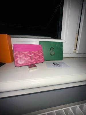 Rosa  plånbok med mönster - Säljer en rosa plånbok  med deras ikoniska grafiska mönster. Plånboken har flera kortfack och är tillverkad i skinn. Perfekt för dig som vill ha något unikt och färgstarkt i fickan.