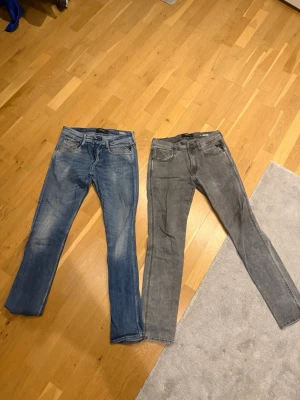 Replay jeans blå och Replay jeans grå - Säljer två par jeans: ett par klassiska blå Levi's med raka ben och ett par grå Replay jeans med smalare passform. Båda har femficksdesign och är tillverkade i slitstarkt denim. Perfekta för dig som gillar stilrena och tidlösa jeans.