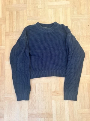 Mörkblå stickad tröja från H&M🥹 - Mysig mörkblå stickad tröja från H&M i ribbat material. Tröjan har en croppad passform, rund halsringning och långa ärmar. Perfekt för kyliga dagar och enkel att styla med jeans eller kjol.