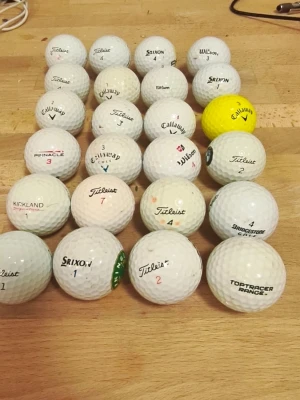 Blandade märken golfbollar mixad färg - Golfbollar från olika märken i blandade färger inklusive vit och gul. Olika modeller och skick, lämpliga för träning eller spel.