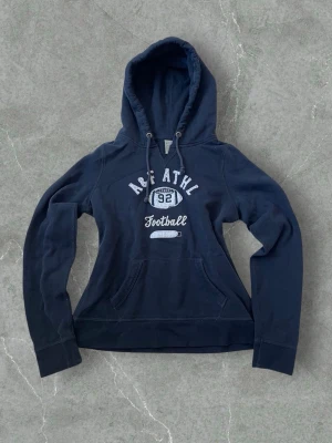 Abercrombie & Fitch Football Hoodie – Women’s Size 38 - Abercrombie & Fitch hoodie with “Football” text on the front. Soft, comfortable and perfect for casual everyday wear. Women’s size 38. Good condition.  #abercrombie #womenshoodie #football #casualwear #streetstyle #size38 #vinted