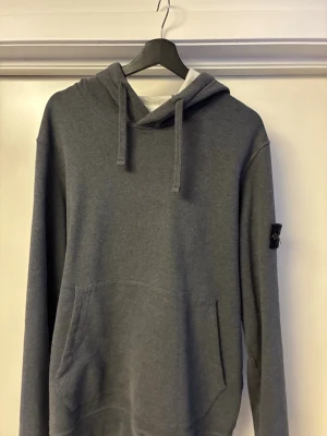Stone Island hoodie - Säljer en mörk grå Stone Island hoodie, klassiska patchen to armen, bra passform, för dig som vill ha en hållbar och stilren hoodie