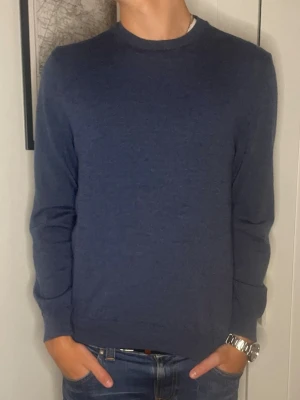 Merinoullströja ifrån Oscar Jacobson - Klassisk mörkblå stickad tröja från Oscar Jacobson i storlek L. Tröjan är i storlek L men sitter som S. Modellen i bild 5 är för referens 180. Merinoullströja i topp skick! Hör av er vid eventuella frågor! 😊