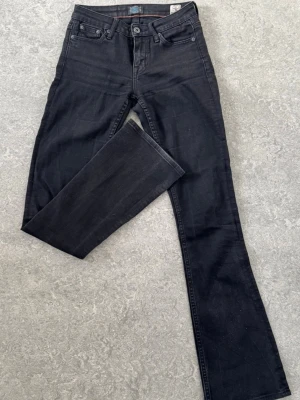 Svarta Crocker jeans bootcut - Säljer ett par svarta jeans från Crocker med klassisk femficksmodell och bootcut-ben. Jeansen har normal midja och är tillverkade i ett mjukt bomullsmaterial med lite stretch. W25 L33 low Bootcut 
