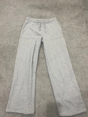 Gråa mjukisbyxor med fram och bak fickor - Gråa mjukis byxor med snöre, fram och bak fickor. Köpt för 150kr säljs för 60kr. Pris kan diskuteras. 