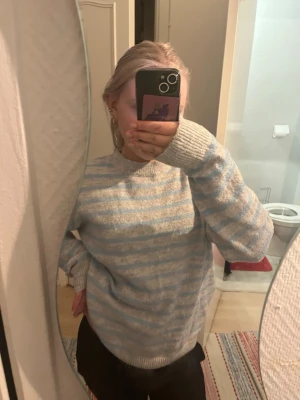 Stickad tröja fån Gina❤️💗 - Mysig stickad tröja med ljusblå och vita ränder. Tröjan har rund halsringning och långa ärmar med ribbade muddar. Perfekt för kyliga dagar och enkel att matcha med jeans eller kjol.