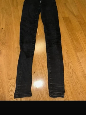 Svarta skinny jeans XS - Säljer ett par svarta skinny jeans i storlek XS. De har klassisk femficksdesign, dragkedja och knapp framtill. Jeansen är tighta hela vägen ner och har en enkel, stilren look som passar till allt. Materialet är stretchigt för extra bekvämlighet.