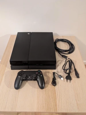 PlayStation 4 - Sony PlayStation 4 spelkonsol i fint skick. Inkluderar en original DualShock 4-handkontroll, HDMI-kabel, strömkabel och USB-laddningskabel. Konsolen har inga synliga repor eller skador och fungerar utmärkt för gaming.