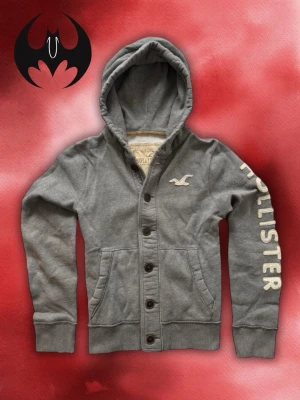 Grå Hollister Kofta (Sällsynt) - Sällsynt Grå Hollister Kofta | mycket bra skick, snöre saknas | Size M/L | Längd: 68cm Axelbredd: 48cm Armlängd: 72cm | Lägg inte bud utan avsikt att köpa