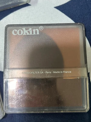 Cokin Kamerafilter (Spot Incolor 1, CromoFilter, Studiolato) - Sats med Cokin kamerafilter, inklusive Spot Incolor 1, CromoFilter och Studiolato. Passar till systemkameror för kreativa fotoeffekter. Fodralen har synligt slitage men filtren ser ut att vara i gott skick. Tillverkade i Frankrike.