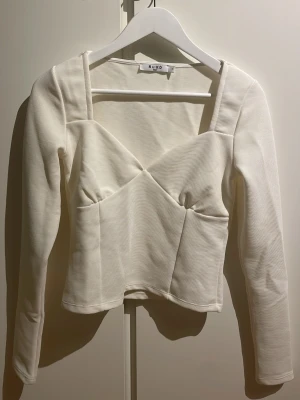 Vit långärmad topp från NA-KD - Säljer en ribbad vit topp från NA-KD i storlek S. Endast använd två gånger, som att den skulle vara i ny skick💗