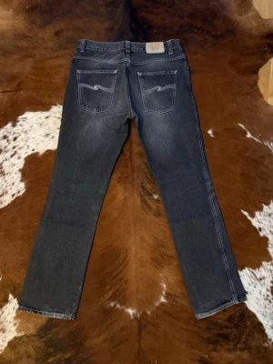 Nudie LowSlimJim Slim/Bootcut - Tjena! Säljer dessa riktigt feta vintage nudie LowSlimJim, byxorna är slimfit med lite lite bootcut, W33/L32, modellen är 188cm, hör av dig vid funderingar!🙌