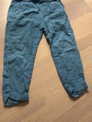 Blå barnbyxor från LC Waikiki i strl 104/110 - Snygga blå byxor från LC Waikiki i storlek 104/110 för barn. Byxorna har en klassisk passform med uppvikta benslut och sidofickor. Perfekta för en chill och bekväm stil till vardags. 