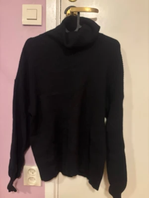 Svart polotröja från BikBok - Mysig svart polotröja från BikBok i ribbstickat material. Tröjan har lång ärm och en hög, bred polokrage som ger en chill vibe. Perfekt till höst och vinter när du vill vara både varm och snygg.