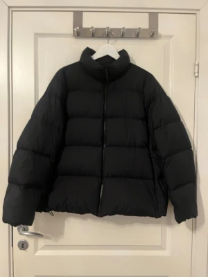 Svart pufferjacka från Uniqlo L - Säljer en svart pufferjacka från Uniqlo, ultra light down i storlek L. Jackan är lätt, har hög krage och dragkedja framtill. Tillverkad i slitstarkt material med vattenavvisande yta och dunfyllning. Stor i storleken. Använd nån enstaka gång.