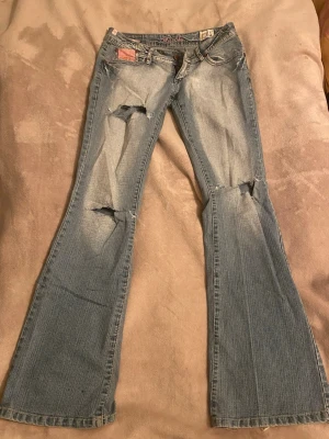 Low waist jeans -  Säljer ett par ljusblå bootcut jeans från märket Miss O&Y. Dessa jeans har låg midja och är i bootcut modell med slitningar på framsidan. Sjukt snygga jeans som jag tyvärr behöver sälja då dem är förstora för mig😭Midjemåttet är ca 38cm (rakt över) och innerbenslängden är ca 83cm💗notera att det är ett litet hål för bak (se sista bilden), går lätt att sy ihop om man vill💗