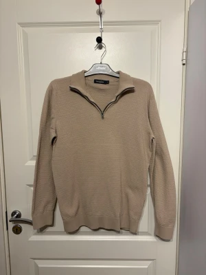 Beige half zip tröja från Dressmann - En beige långärmad tröja från Dressmann🤩 Tröjan har en snygg strukturstickning, hög krage och half zip-dragkedja framtill, i storlek M Perfekt för lager på lager och enkel att matcha med jeans eller chinos. Går jättebra att använda "Köp nu"! Vi skickar inom 1-2 dagar💕 Bara att skriva vid funderingar🤗