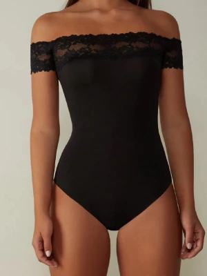 Svart off shoulder spetsbody Intimissimi  - Säljer en svart body med off shoulder-design och bred spetskant upptill. Tight passform som framhäver figuren och ger en stilren look. Den är från Intimissimi i väldigt bra skick.