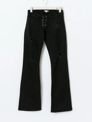 Svarta bootcut jeans med snörning - Säljer ett par svarta bootcut jeans med snörning framtill och slitna detaljer på benen. Byxorna har hög midja och är tillverkade i ett stretchigt jeansmaterial. Snygg passform som markerar midjan och ger en cool vibe.