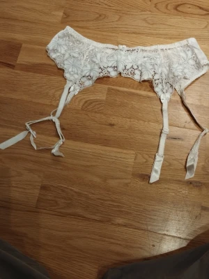 Vit spets strumpebandshållare Twilfit - Säljer en vit strumpebandshållare från Twilfit med vackra spetsdetaljer och blommigt mönster. Justerbara band med små rosetter och satinband.  Perfekt för alla hjärtans dag  / Valentine's day. Jag har fler annonser uppe och ger mängd rabatt, så kolla gärna min sida!