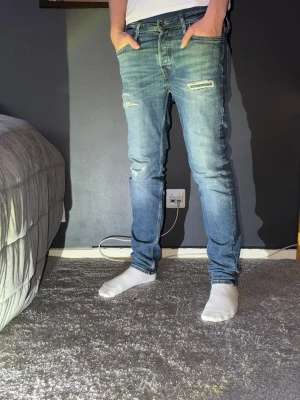 Blå  jeans Jack & Jones 27/30 - Säljer ett par blå  jeans från Jack & Jones i storlek 27/30. Jeansen har slitningar vid knäna och låren. 