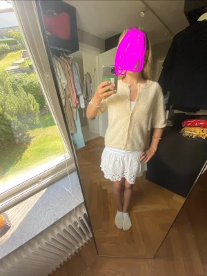 Krämvit kofta med pärlknappar - Superfin krämvit kofta med korta ärmar och pärlknappar framtill. Mjuk och fluffig känsla, perfekt till sommaren eller våren. Enkel, rak passform och rund halsringning. Passar perfekt till kjol eller jeans för en söt look.