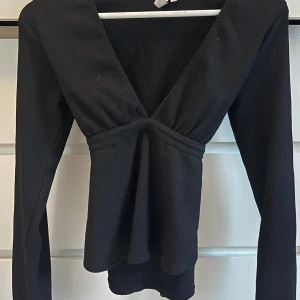 Nelly tröja  - Svart blus från Nelly storlek S/m. V-ringad med knyte i midjan