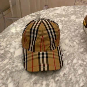 Burberry keps i beige  - Säljer en klassisk Burberry keps som är helt oanvänd med lappen kvar 