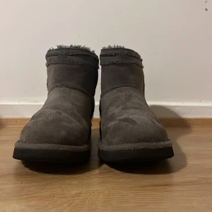 Grå UGG boots i mocka - Säljer mina jättesnygga grå uggs sån här haft i en säsong, tyvärr är för små😔 Som ni kan se har den en pytteliten defekt, fast man ser knappt, de har inga effekter på sulan eller inuti skorn, de är också Limited edition eftersom de är från Amerika, man kan se det på folkmärket om man kollar noggrannt, och de har broderi  uppe vid skorn, PRIS KAN DISKUTERAS!!!!💕💕💕
