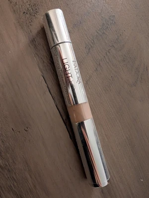 Isadora Light Up Concealer Warm Sand - Isadora Light Up Brightening Cushion Concealer i nyansen 05 Warm Sand. Kommer i en smidig silverfärgad penna med cushion-applikator för enkel applicering. Perfekt för att ljusa upp och täcka mörka ringar under ögonen med en naturlig finish. Ny.