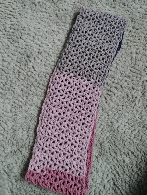 Stickad halsduk i rosa och grå toner - Mysig och handgjord virkad halsduk i mjuka nyanser av rosa och grått. Halsduken har ett luftigt, glest mönster och är perfekt att vira runt halsen för extra värme. Passar dig som vill ha en personlig accessoar med lite glittrig känsla. Virkad av mig om någon undrar! 🙃🤗