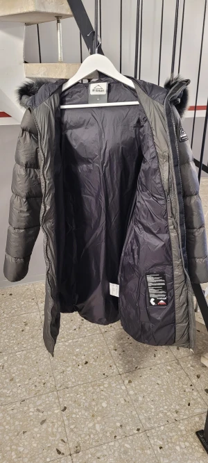 Mörkgrå pufferjacka med päls från McKinley - Snygg mörkgrå pufferjacka från McKinley med äkta päls,storlek 40,jacka är som ny ,dunjacka. 