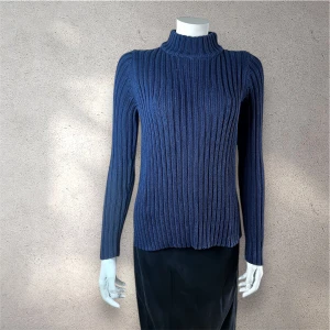  Ribbad tröja stickad från Gina tricot - Snygg marinblå stickad tröja med ribbad struktur och lång ärm. Tröjan har en hög krage som ger en cool vibe och passar perfekt till jeans eller kjol. Den är mjuk och skön, med en klassisk passform som sitter normalt. Perfekt för dig som gillar stilrena och tidlösa plagg. #stickadtröja #ribbadtröja #ginatricot