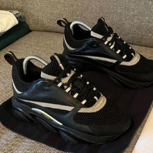 DlOR 22 svart - Snygga chunky sneakers i svart med detaljer i grått och vitt. Ovandelen är i mesh och syntet, med snörning och platt sula. Skorna har en sportig vibe och passar perfekt till streetwear. De har rund tå och coola kontrastdetaljer. D 22 billig dunder pris