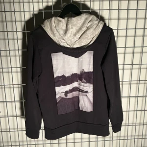 Limitato- Tröja, "Wearable Art", hoodie med tryck  - Limitato- Tröja, Huvtröja/Hoddie, zip-up hoodie med fototryck, samarbete med Camilo Rios (Miami baserad modefotograf)  Material: 100% bomull -Storlek: Small (true to size) Mått- Längd: 68cm Axlar: 42 Chest: 50cm/100 Waist: 46 Arms: 48 -Condition: Mycket bra, sparsamt använd, utan anmärkningar  