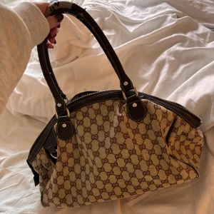 Gucci väska - Skitsnygg gucciväska som tyvärr ej kommer till användning! Deffekt på handtagen (se bild 1), går säkert att lösa hos skräddare eller liknande. Skriv för mått! Köpt seconhand 