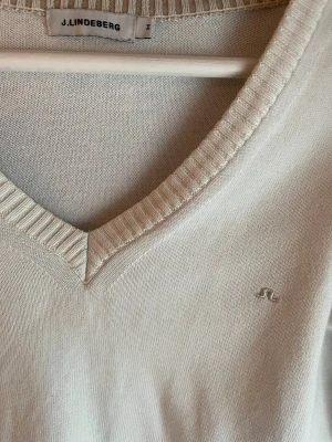 Vit v-ringad tröja från J.Lindeberg - Vit v-ringad tröja från J.Lindeberg i mjuk stickad bomull. Perfekt för dig som gillar clean och stilren look. Hör av dig vid minsta fundering!:)