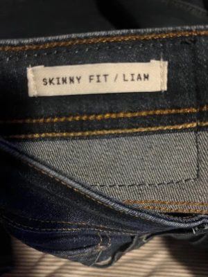 Jack & Jones Skinny Fit Liam Jeans - Mörkblå jeans från Jack & Jones i modellen Skinny Fit Liam. Snyggt smal passform med klassiska fem fickor och kontrastsömmar. Jeansen har en ren look med lätt slitning och är tillverkade i stretchig denim för extra komfort. De är riktigt feta och i ett otroligt skick🤩🤩🤩