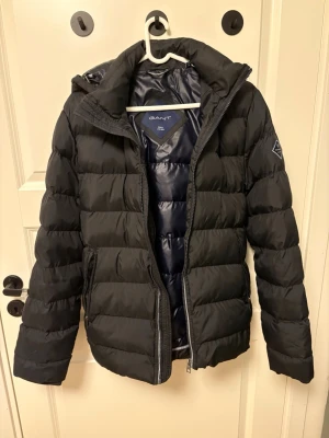 GANT Vinterjacka - Säljer en vinterjacka av märket GANT i en mörkblå färg. Jackan är perfekt nu till vintern och är riktigt snygg. Jackan är i mycket bra skick och har inga defekter. 