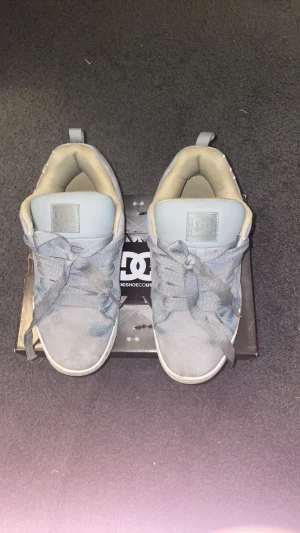 Ljusblå DC sneakers med beige detaljer - Säljer ett par ljusblå DC sneakers med beige insida och stora DC-loggor på sidan. Skorna har breda skosnören och är tillverkade i mockaliknande material med perforerade detaljer. Klassisk låg modell som passar perfekt till streetwear. Priset kan diskuteras 