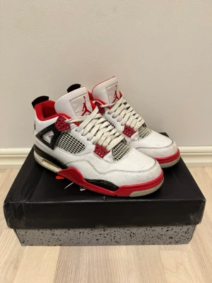 Air Jordan 4 Retro Fire Red sneakers 43 - OBS PRISET ÄR EJ SPIKAT SÅ SKRIV GÄRNA! Storlek 43). Säljer ett par Air Jordan 4 Retro Fire Red sneakers med vit läderöverdel, röda och svarta detaljer samt meshpaneler på sidorna. Skorna har synlig Air-dämpning i sulan, klassisk Jumpman-logga på plösen och Nike Air-logga på hälen. Röd innerfoder och svarta plastdetaljer.