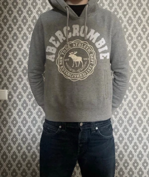 Abercrombie & Fitch hoodie (Vintage) - Tja, säljer denna feta Abercrombie & Fitch hoodien som är i mycket bra skick. Storleken M men sitter mer som XS och passar perfekt för dig som är mellan 160-165 cm lång! Modellen är 170, 55kg och sitter alldeles för litet. Mitt pris är 599, men kan givetvis diskuteras vid snabb affär! Hör av er vid frågor🙌