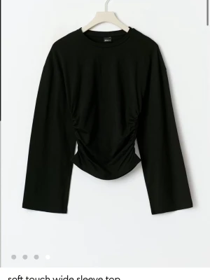 Svart långärmad topp Gina Tricot - Svart långärmad topp från Gina Tricot med figurnära passform. Enkel och stilren design som passar perfekt till jeans eller kjol. Mjuk och skön känsla, perfekt för lager-på-lager eller som den är.