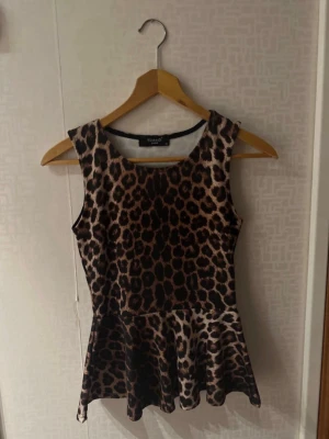 Leopardmönstrad peplum-topp – XS - Snygg leopardmönstrad topp från Sisters Point i storlek XS. Ärmlös modell med peplum-nederdel som sitter jättefint. Perfekt till fest, utekväll eller stylad mer casual.  • Storlek: XS • Märke: Sisters Point • Färg: Leopardmönstrad  Trendigt plagg som verkligen sticker ut 🖤🤎